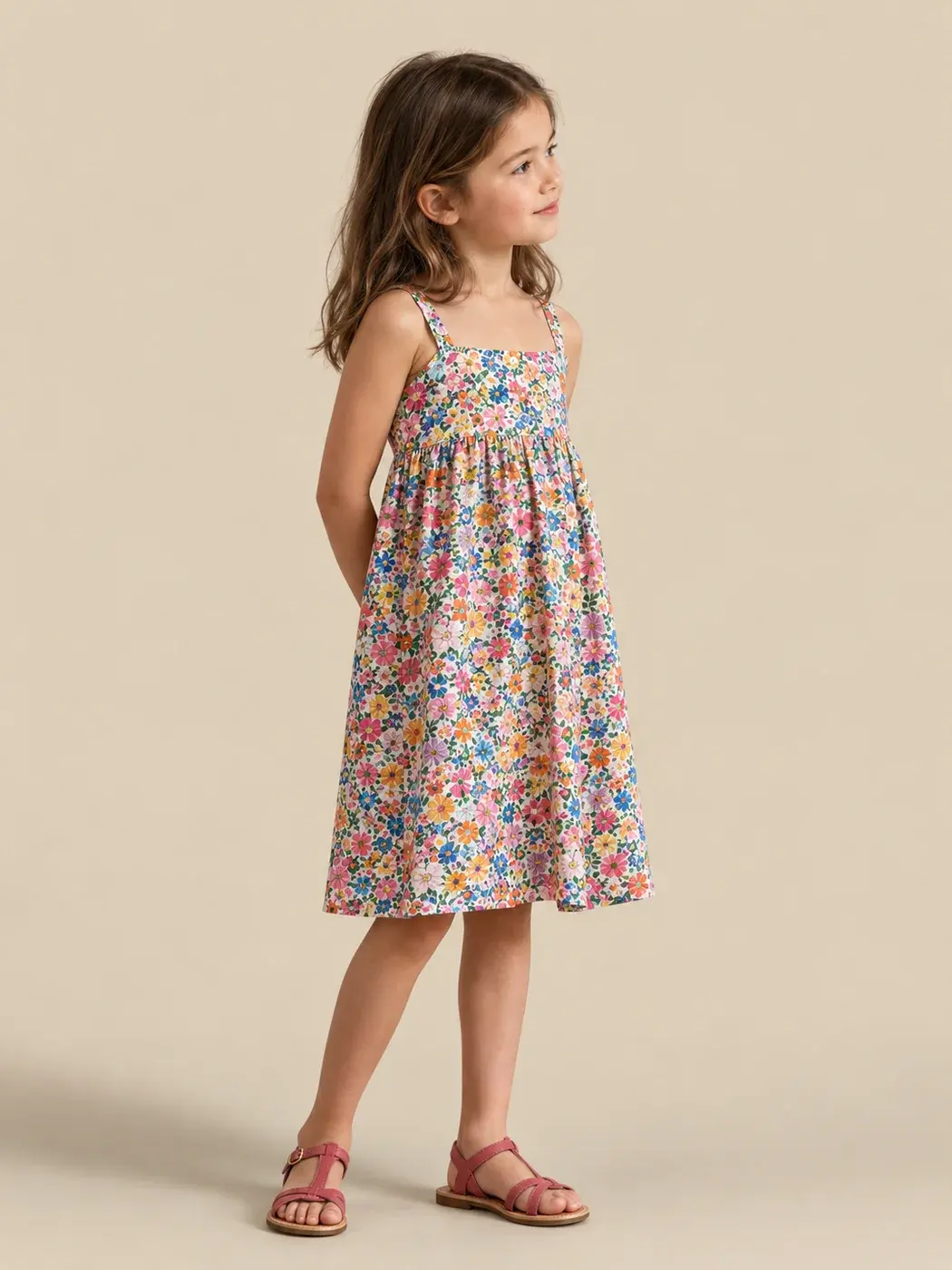 Robe fillette à fleurs portée par une enfant sur un fond uni